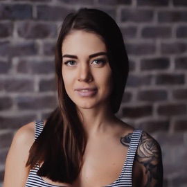 a photo of a brunette haired female with a tattoo on her left shoulder